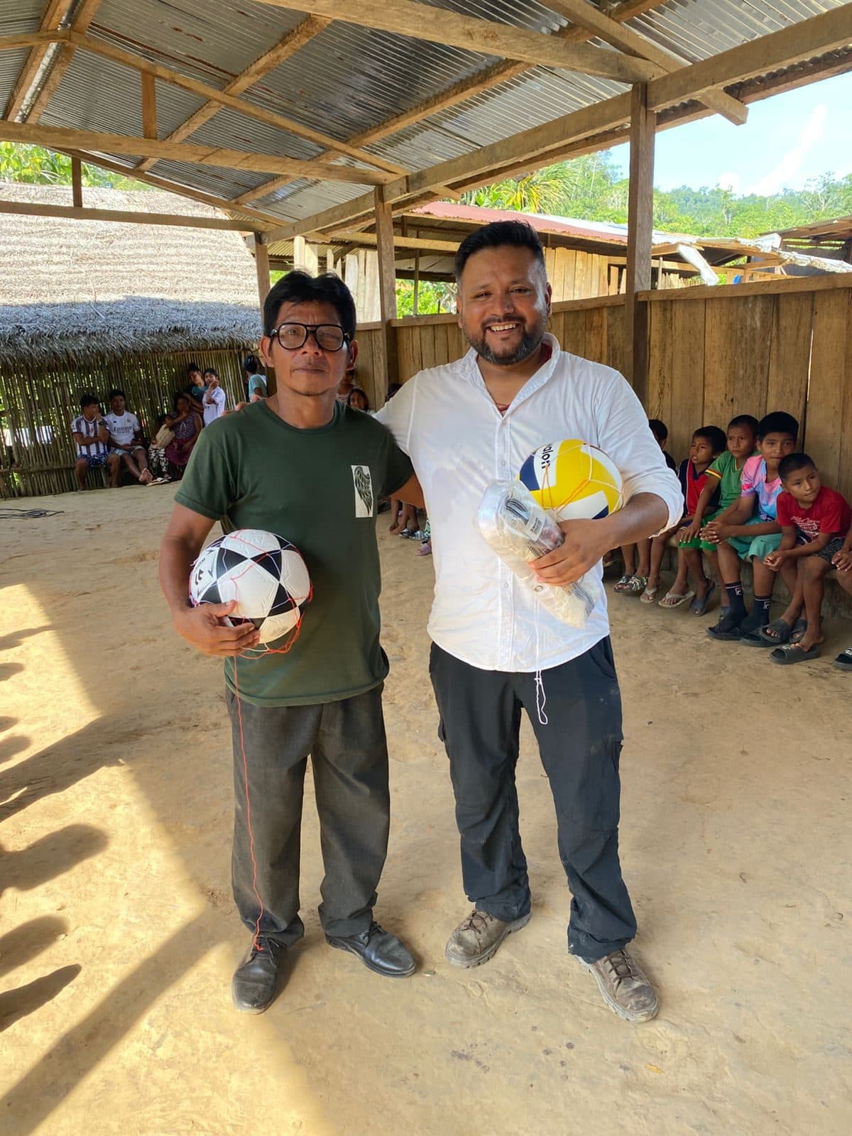 Jóvenes de una comunidad amazónica recibiendo balones en una actividad de Tendiendo Puentes.