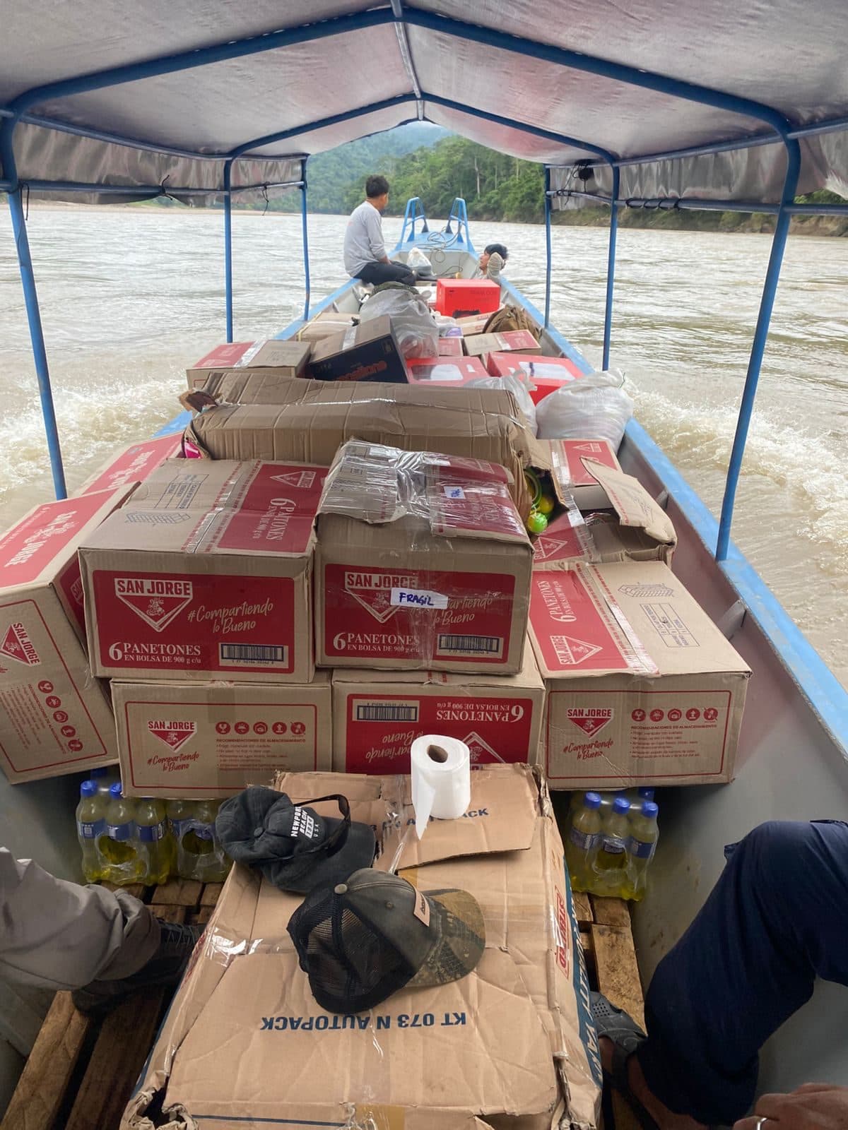 Embarcación con donaciones navegando un río amazónico hacia comunidades nativas del Perú.